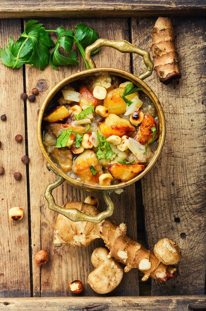 Jerusalem artichoke vegetable soup in retro plate.Vegan soup