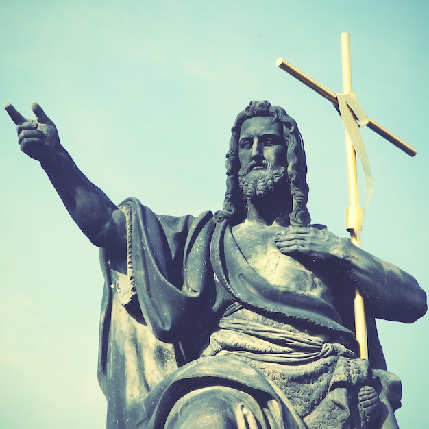 Photo jesus with cross at charles bridge in prague. retro style filtred image