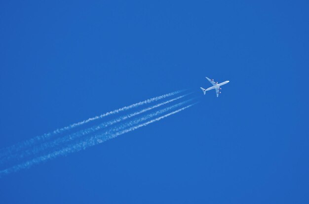 飛行機雲で高空を飛ぶジェット機