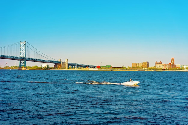 Jet Boat at Benjamin Franklin Bridge over Delaware River in Philadelphia, Pennsylvania, the USA.