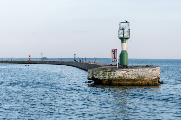 Molo vicino al porto marittimo con boe moderne del faro