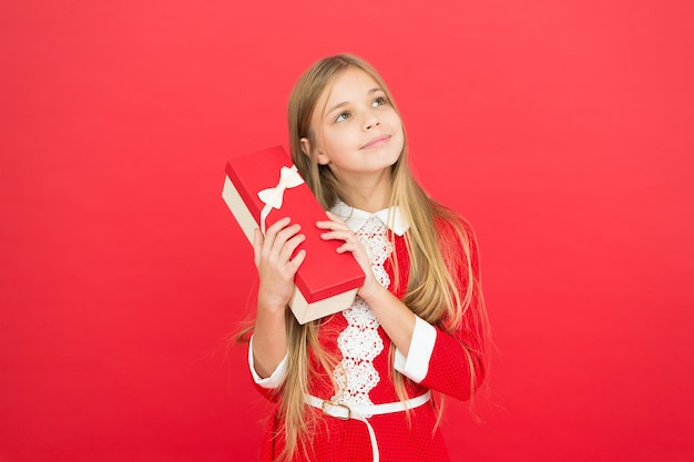 Jeugd geluk. familie en liefde. kinderdag. Goed ouderschap. Kinderopvang. klein meisje kind. School. gelukkig meisje op rode achtergrond. verjaardagscadeau doos. Mocht ik willen. Moment van geluk.