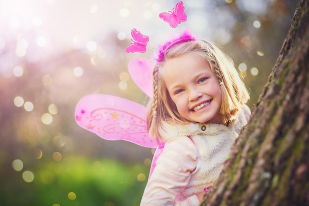 Foto jeugd is magisch portret van een schattig klein meisje verkleed als een fee en plezier buiten