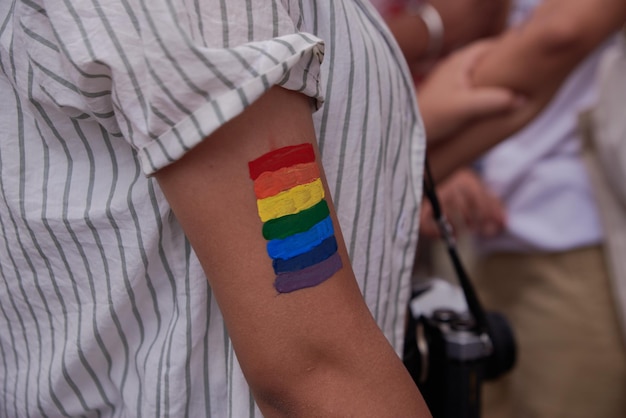 Foto jeugd schildert regenboogvlag in de arm