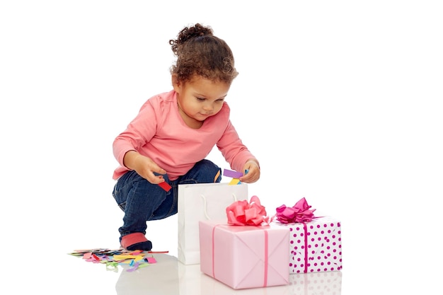 jeugd, verjaardag, feest, feestdagen en mensen concept - gelukkig klein Afrikaans Amerikaans babymeisje met geschenkdozen spelen met confetti en boodschappentas