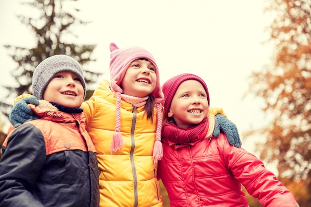 jeugd, vrije tijd, vriendschap en mensen concept - groep gelukkige kinderen knuffelen in herfst park