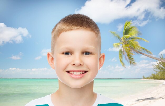 jeugd, zomer, reizen, vakantie en mensen concept - glimlachend jongetje over strand achtergrond