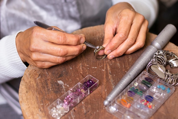 Photo jeweler hands putting a jewel on ring high view