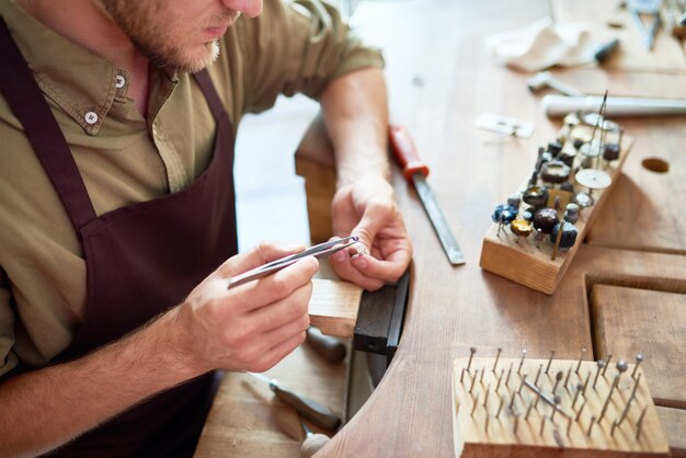 Photo jeweller making silver ring in workshop