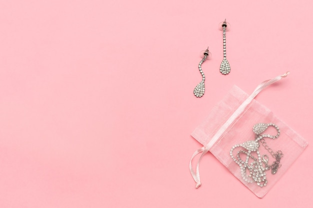 Jewelry as gift on a pink background with copy space. Valentine's Day, dating, love, birthday concept.