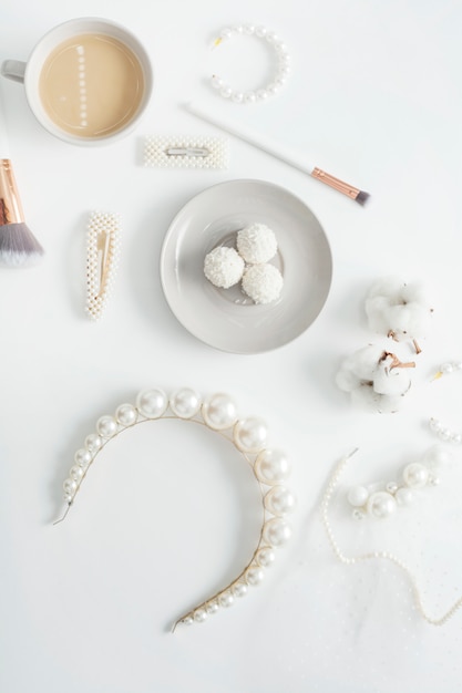 Jewelry for the bride, pearls, makeup brushes, delicate colors, candy and coffee, on a white space