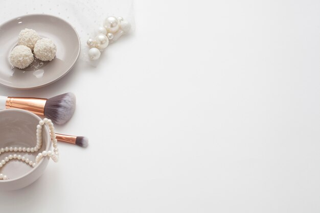 Jewelry for the bride, sweets and cup of coffee, on a white background. Concept weddings, preparation and morning of the bride.