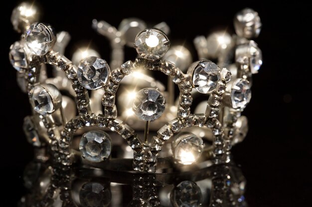 Photo jewelry crown with shiny stones on a black background.