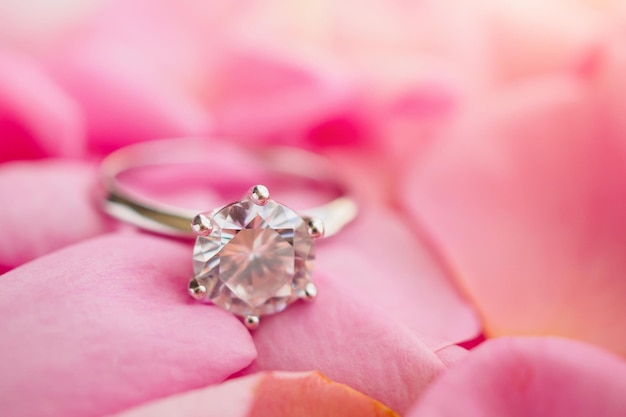 Jewelry diamond ring on beautiful pink rose petal background close up