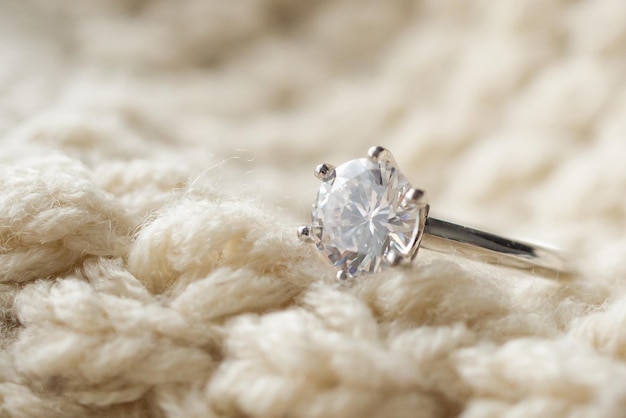 Jewelry diamond ring on knitted fabric background