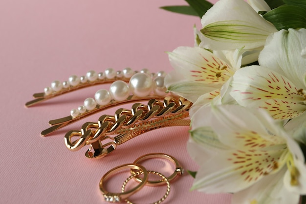 Jewelry and flowers on pink, close up