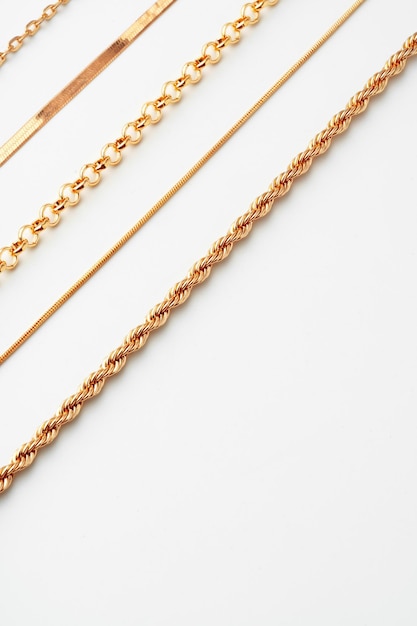 Jewelry set of golden chains on the white background