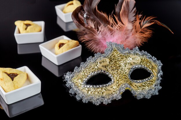 Jewish hamantaschen cookies and carnival mask for Purim.