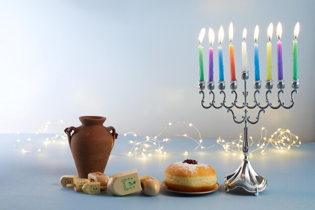 Jewish holiday hanukkah background with menorah traditional candelabra spinning top and doughnut on ...