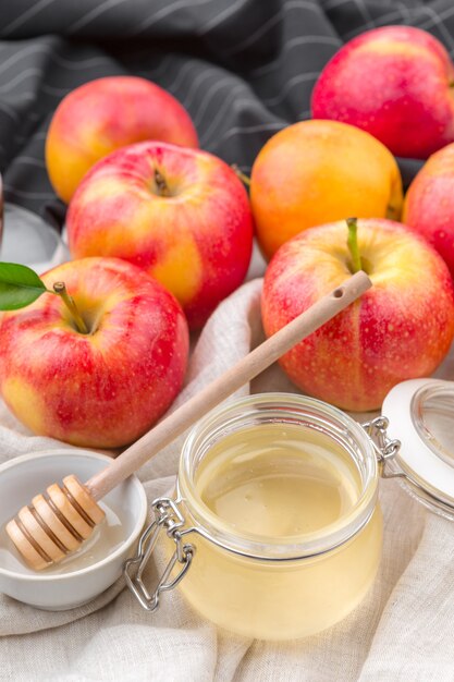 Jewish holiday Rosh Hashanah background with honey and apples on wooden table.