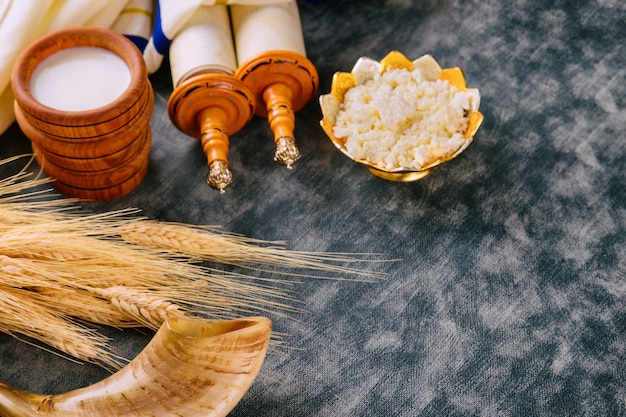 Jewish holiday Shavuot for kosher set dairy food on torah scroll and tallis