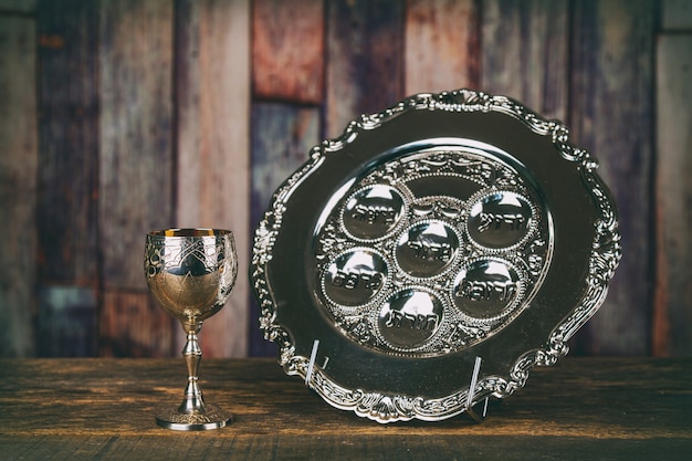 Jewish holidays passover pesach matzah and a silver cup full of wine with a traditional blessing