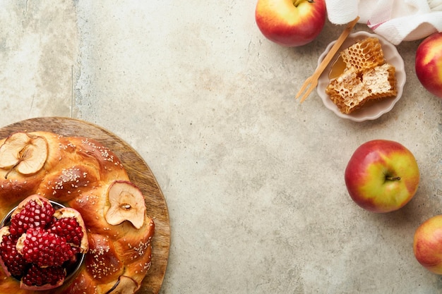 유대인 휴일 Rosh Hashanah 또는 Rosh Hashana 석류 사과 꿀과 소박한 회색 테이블 배경에 둥근 할라 유대인 가을 축하 Shana Tova Yom kippur 개념 Top view