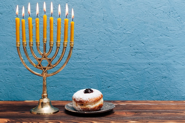 Photo jewish menorah with tasty donut