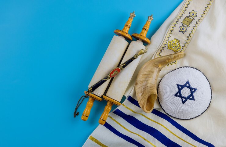 Photo jewish prayer book with torah scroll and shofar horn, prayer shawl tallit
