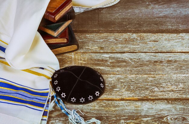 Jewish ritual with kippah in talit praying in the Jewish hebrew prayer book on a synagogue