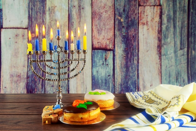 Jewish symbol jewish holiday hanukkah with menorah traditional candelabra and wooden dreidels spinni...