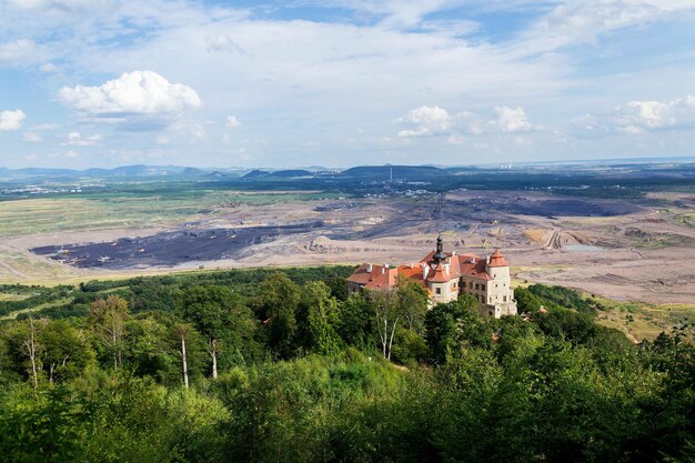 Jezeri Castle with Czechoslovak army coal mine in background Horni Jiretin Most district Ustecky region Czech Republic sunny summer day