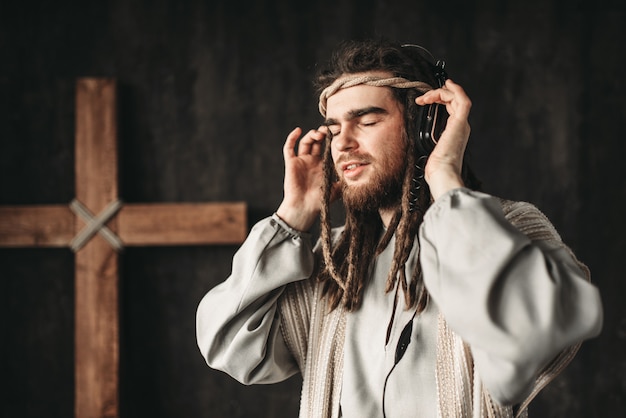 Jezus Christus luisteren naar muziek met een koptelefoon, kruisiging kruis op zwart