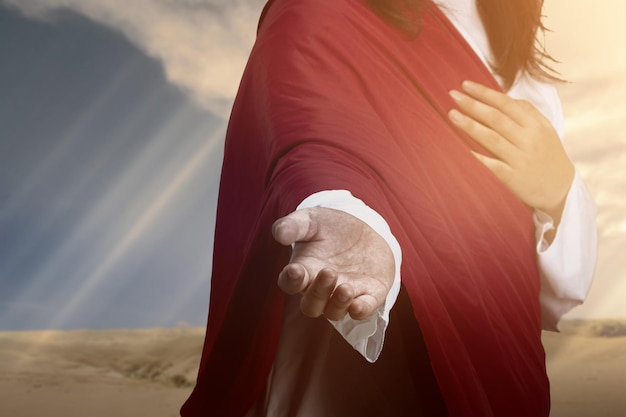 Jezus Christus met open palm die helpende hand geeft met zonlichtachtergrond