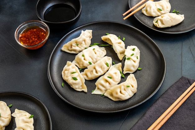 Gnocchi jiaozi gyoza cotti al vapore su piatti neri