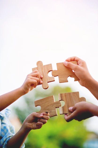 Foto jigsaw in mano i pezzi del puzzle si riuniscono il lavoro di squadra il concetto di pianificazione del lavoro come una squadra