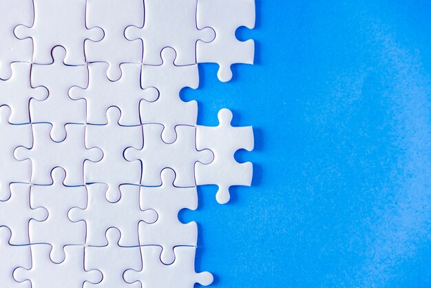 Jigsaw puzzle white on blue background.