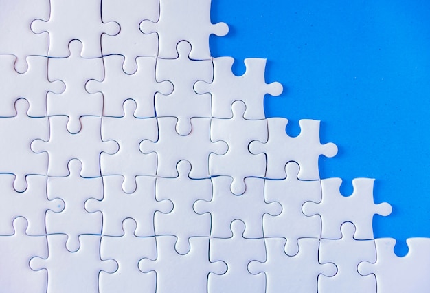 Jigsaw puzzle white on blue background.