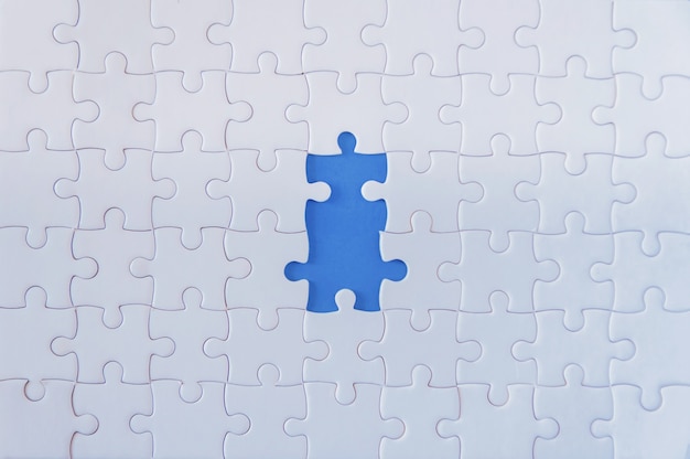 Foto jigsaw puzzle bianco su sfondo blu.