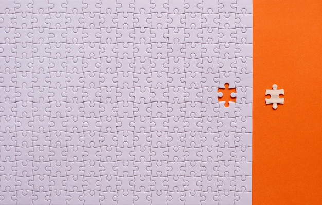 写真 ジグソー パズル白い色パズルのピース グリッド成功モザイク ソリューション テンプレートテキストのオレンジ色の背景コピー スペースに水平トップ ビュー