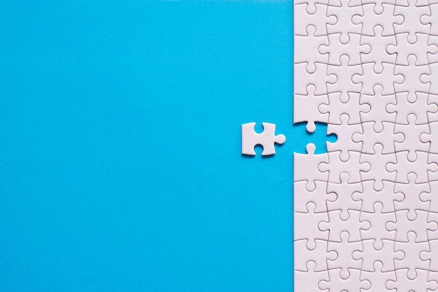 Foto puzzle di colore bianco puzzle pezzi griglia modello di soluzione di mosaico di successo orizzontale su sfondo di colore blu copia spazio per il testo vista dall'alto
