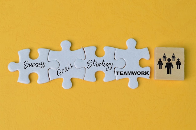 Jigsaw puzzle with text SUCCESS GOALS STRATEGY and TEAMWORK