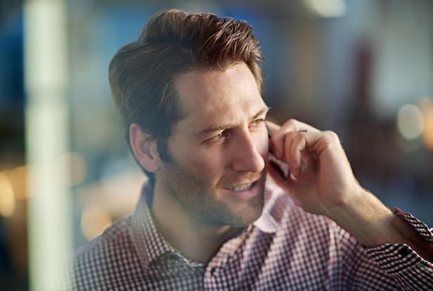 Jij serieus Shot van een knappe zakenman die op zijn mobiele telefoon op de werkplek praat