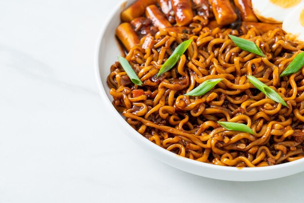 Jjajang Rabokki Korean instant noodles or Ramyeon with Korean rice cake or Tteokbokki and egg in black bean sauce