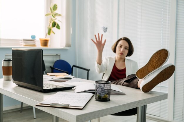 Foto burnout lavorativo stress correlato al lavoro esaurimento fisico o emotivo la donna d'affari stanca getta le carte sgualcite nel cestino sul tavolo