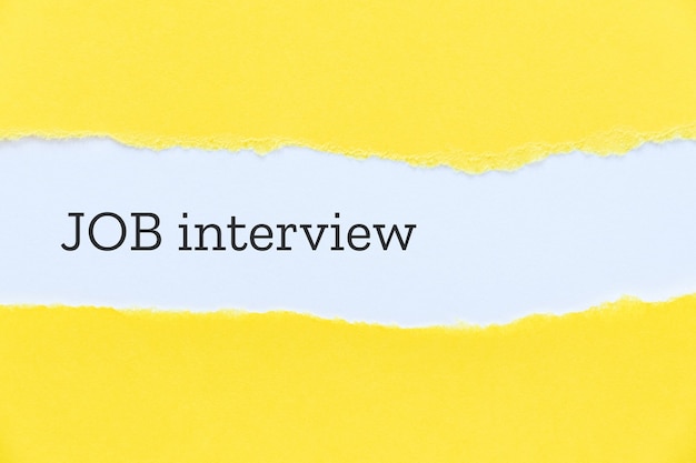 Job interview phrase typewritten on yellow paper backdrop