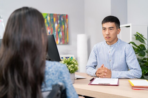 Job interview woman with disability use wheelchair stern male boss asks questions to girl