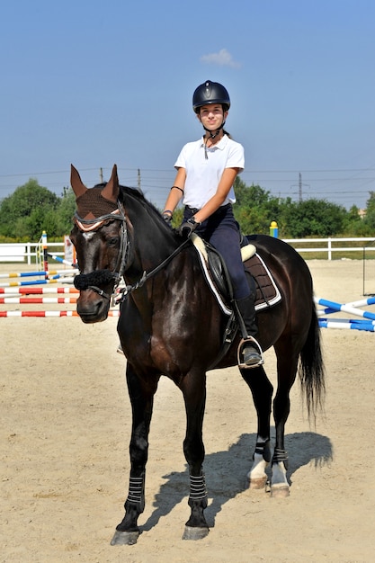 Jockeymeisje op de boerderij met haar paard