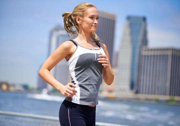 Joggen in de betonnen jungle Shot van een aantrekkelijke blonde vrouw die jogt in een stedelijke omgeving