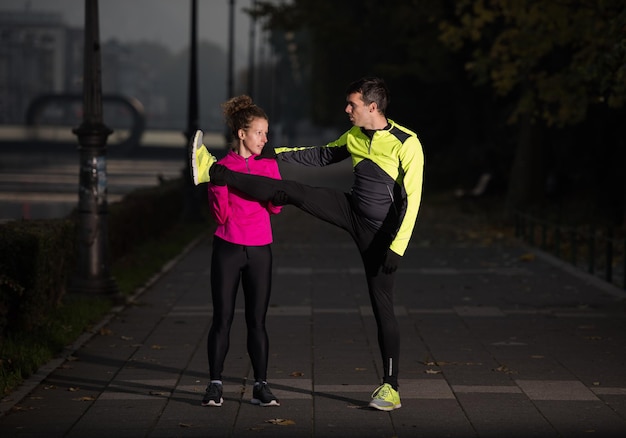 joggend paar opwarmen en strekken voor ochtend hardlopen in de stad